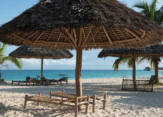 beautiful clean Zanzibar beach with umbrellas and benches