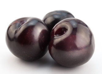 Blue ripe plums on white