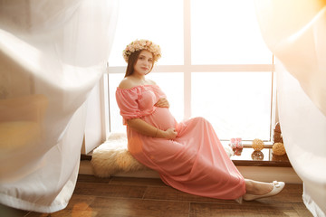 Naklejka premium Portrait Happy pregnant young woman near window 