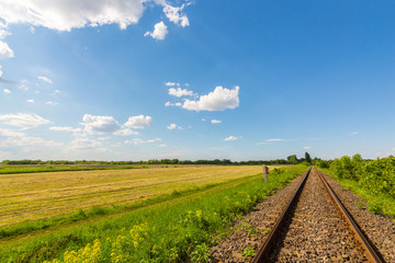 Fototapeta na wymiar Scenic railroad in remote rural area in spring, in Eastern Europe