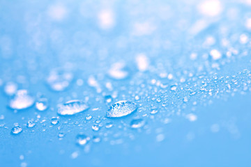 Close up rain water drops on blue sponge surface as abstract background