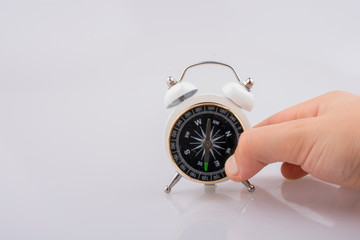 Child holding a compass on an alarm clock