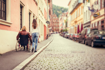 Young Couple In Wheelchair Strolling In The City