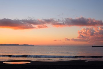 江の島海岸の水溜りに映る朝焼けに染まる雲
朝焼けの茜色の空が海岸の水溜りに映って美しかった。