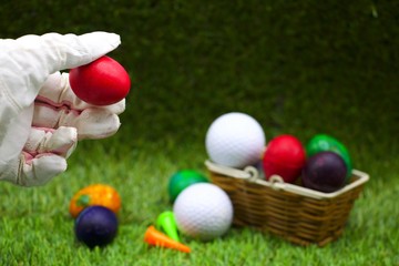 Golf ball with Easter Eggs on green grass