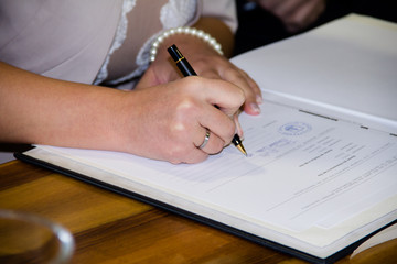 Braut unterschreibt Heiratsurkunde
