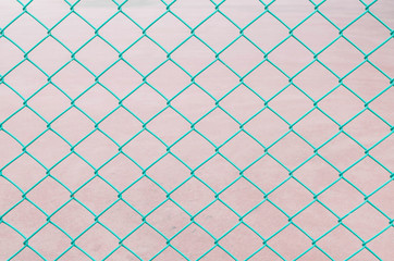 Closeup surface green steel net at the fence of tennis court textured background