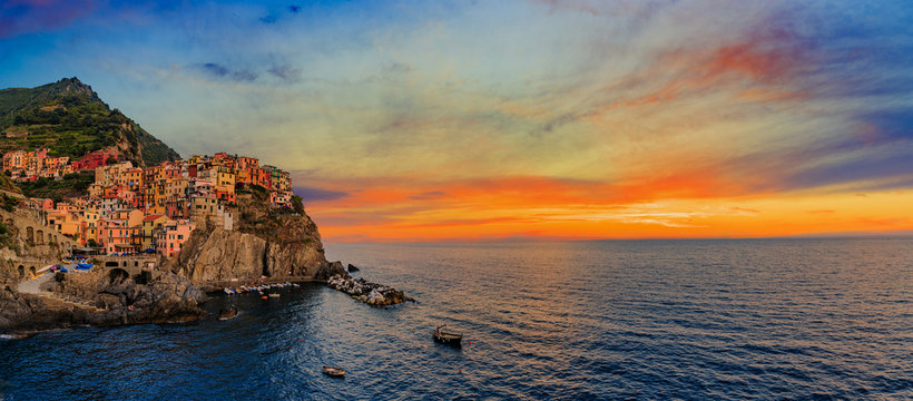 Colorful traditional houses on a rock over Mediterranean sea on sunset, Manarola, Cinque Terre, Italy