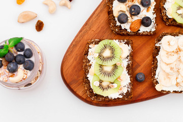 Muesli, nuts and berries. Breakfast preparation. Granola with fresh berries in jar on stone background, top view, banner. Healthy food and Clean Eating concept