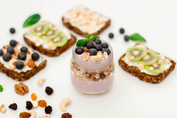 Muesli, nuts and berries. Breakfast preparation. Granola with fresh berries in jar on stone background, top view, banner. Healthy food and Clean Eating concept