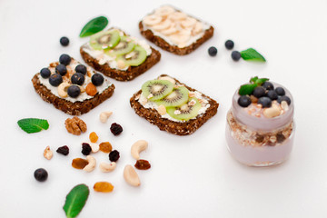 Muesli, nuts and berries. Breakfast preparation. Granola with fresh berries in jar on stone background, top view, banner. Healthy food and Clean Eating concept
