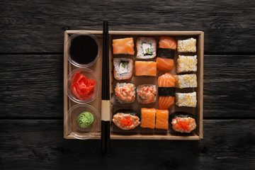 Set of sushi maki and rolls at black rustic wood.