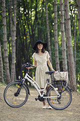 Naklejka premium Young woman against nature background with bike