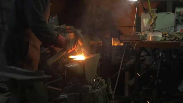 Blacksmith forges iron hammer