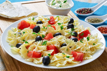 salmon pasta  black olive salad on plate
