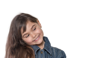 Portrait of long haired brunette little girl isolated on the white background. The girl has her head tilted and is looking into free place ready for your text.