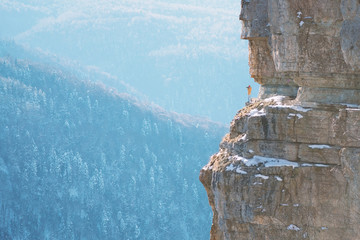 Silhouette of photographer on the edge of rock.
