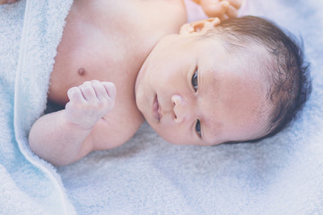 Cute baby lying on back in bathing towel