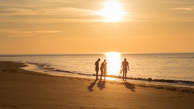 Groep mensen op het strand van Ameland tijdens zonsondergang