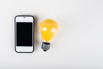 Cell phone and light bulb on a white background. Idea concept.