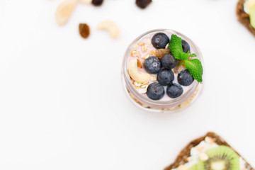 Breakfast. Muesli, nuts and berries. preparation. Granola with fresh berries in jar on stone background. Healthy food and Clean Eating concept