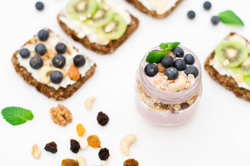 Breakfast. Muesli, nuts and berries. preparation. Granola with fresh berries in jar on stone background. Healthy food and Clean Eating concept