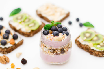 Breakfast. Muesli, nuts and berries. preparation. Granola with fresh berries in jar on stone background. Healthy food and Clean Eating concept