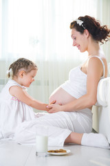 Obraz premium Little girl with her pregnant mother