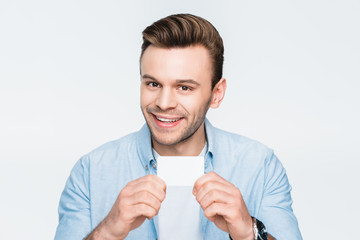 portrait of smiling man showing credit card and looking to camera on white