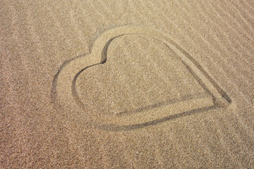 Fototapeta na wymiar Heart drawn on the sandy beach.