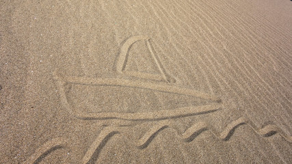 Boat and wave drawn on the sandy beach
