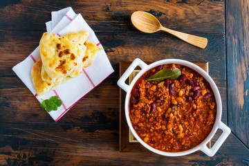Traditional Polish cuisine, stewed Breton beans  with minced beef, bacon, mashed tomatoes, onion, garlic, paprika, bay leaves and spices. White casserole on wooden rustic table, top view. - 137763385