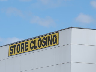 Obraz premium Store Closing black on yellow letters on a white cladded industrial building, Melbourne 2016