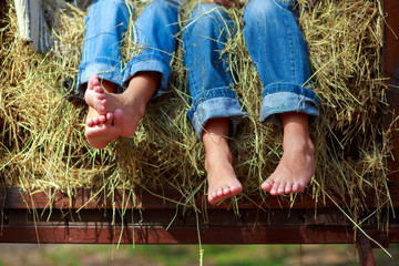 legs in jeans on a haystack