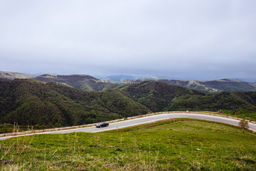 The bend of the mountain road. The car rides on the road