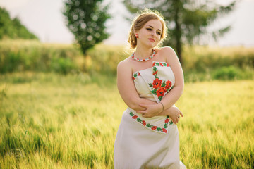 Fototapeta na wymiar Young girl at ukrainian national dress posed at wreath field.