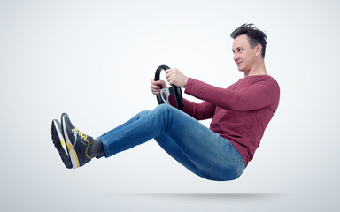 Funny man drives a car with a steering wheel