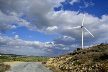 Landscape with cloudy sky and details of a windmill