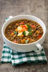 Lentil soup in a bowl on wooden background
