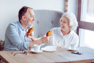 Positive aged couple sitting in the cafe