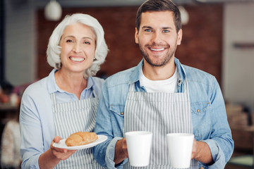 Cheerful cafe owners welcoming guests