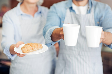 Pleasant hospitable waiters welcoming guests