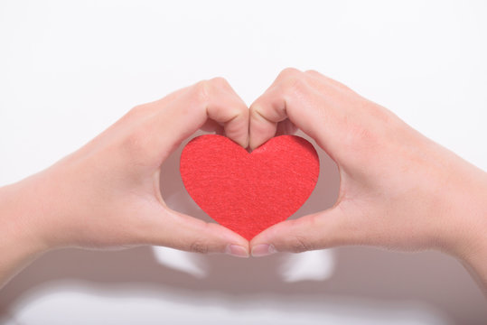 Valentines day and love concept.Two hands holding a red heart shape decoration on white background.