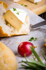Cheese with white mold, radish, grapes and baguette with herbs