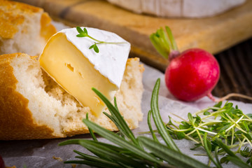 Cheese with white mold, radish, grapes and baguette with herbs