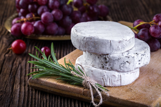 Camembert cheese with grape and branch of rosemary