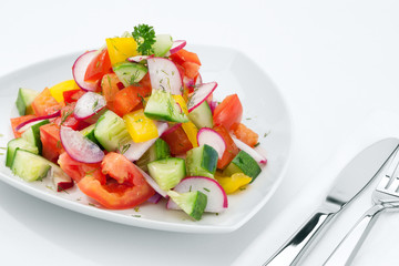 close up view of fresh vegetable salad on white background