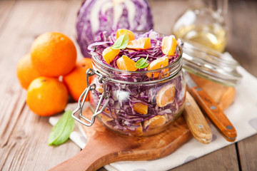 Red cabbage tangerines and pine nuts salad. Selective focus. Copy space.