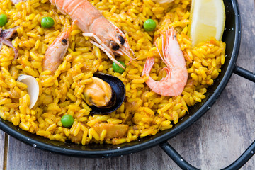 Traditional spanish seafood paella on wooden background
