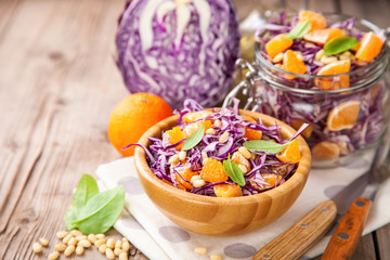 Red cabbage tangerines and pine nuts salad. Selective focus. Copy space.